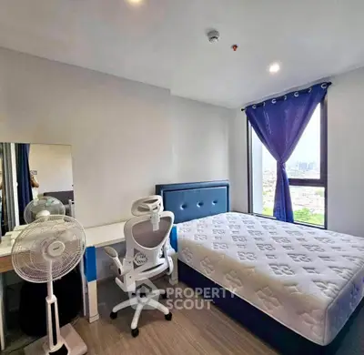 Modern bedroom with city view, featuring a comfortable bed, desk, and chair, ideal for urban living.
