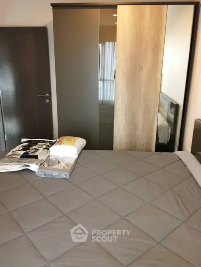 Cozy bedroom with modern wardrobe and stylish bedding in a contemporary apartment.
