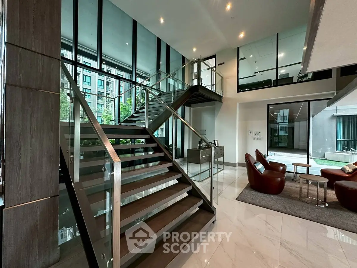 Luxurious modern building lobby with sleek staircase and stylish seating area