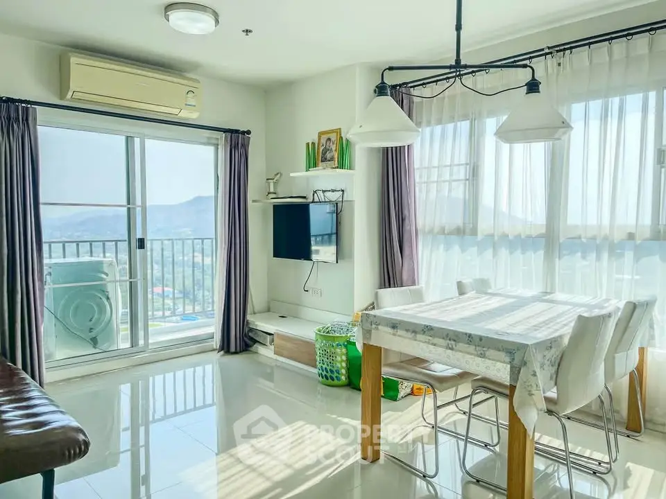 Bright dining area with mountain view, modern decor, and ample natural light in a stylish apartment.