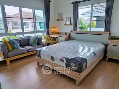 Spacious bedroom with modern decor and large windows offering natural light.