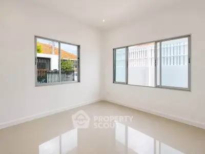 Bright empty room with large windows and glossy tiled floor, perfect for customization.