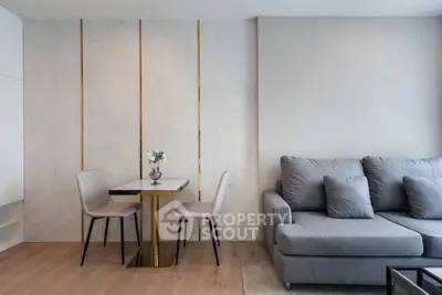 Modern living room with stylish grey sofa and elegant dining area