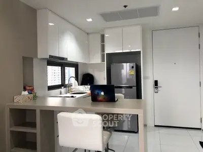 Modern kitchen with sleek white cabinets and breakfast bar in a stylish apartment.