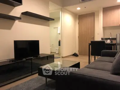 Modern living room with sleek furniture and open kitchen layout in a stylish apartment.