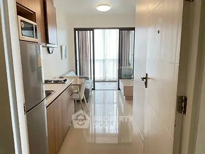 Modern open-plan living room with kitchen and balcony in a stylish apartment.