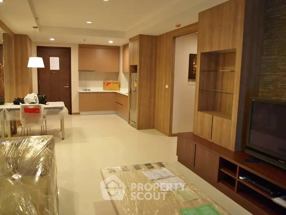 Spacious modern living room with open kitchen layout and stylish wooden furniture.