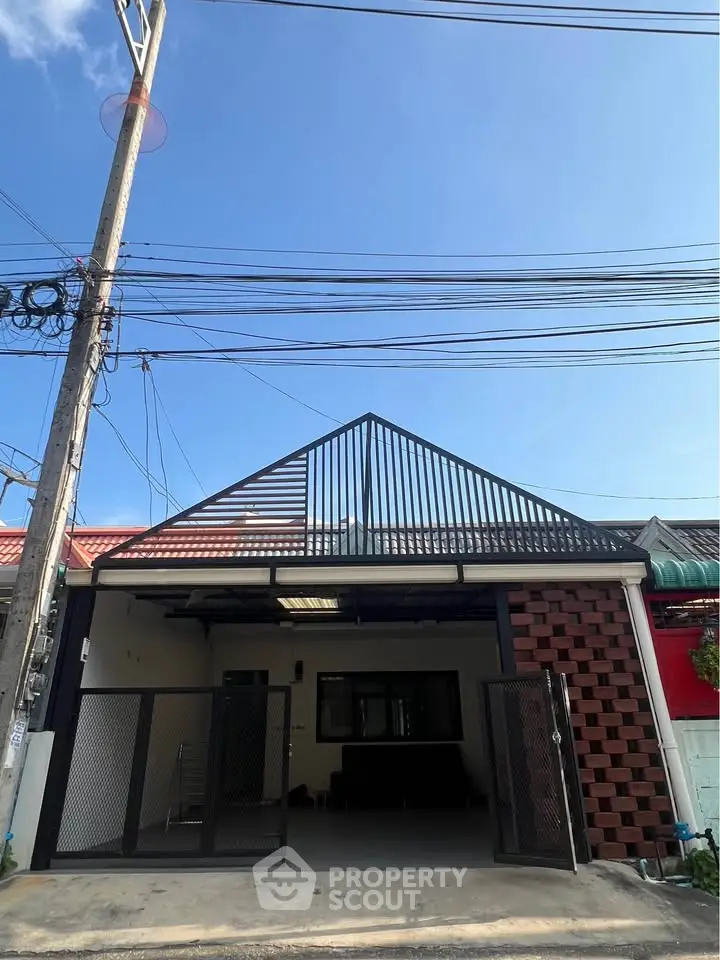 Modern townhouse exterior with unique architectural design and gated entrance.