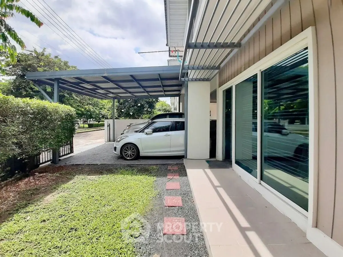 Modern home exterior with carport and lush greenery, perfect for urban living.