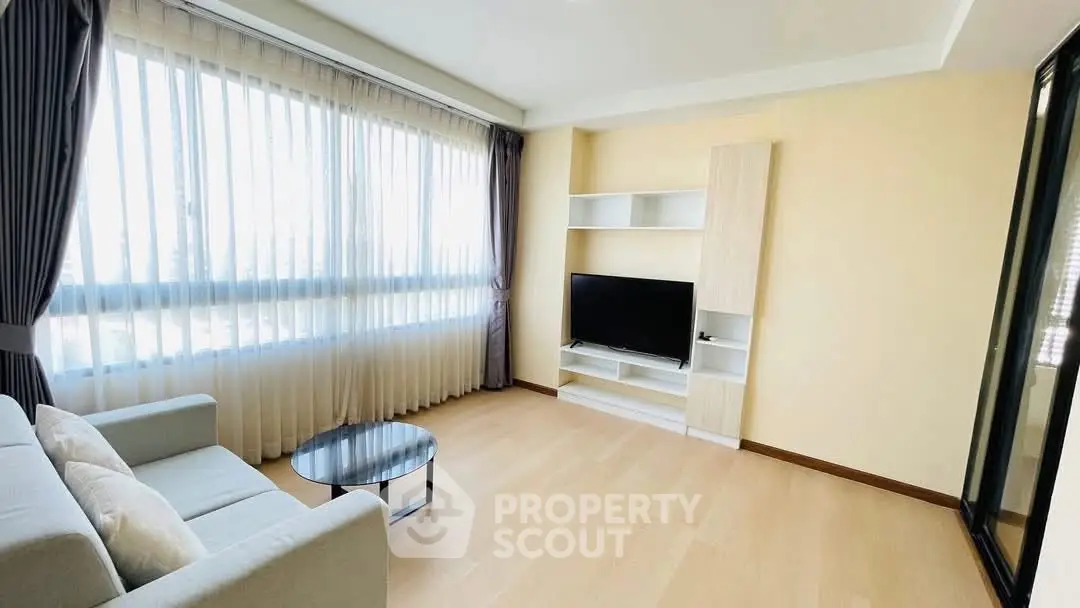Bright and spacious living room with large windows and modern furnishings