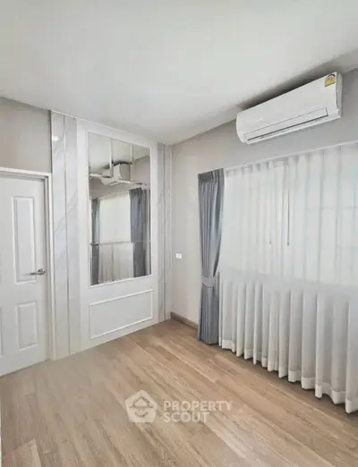Spacious bedroom with elegant flooring and modern air conditioning