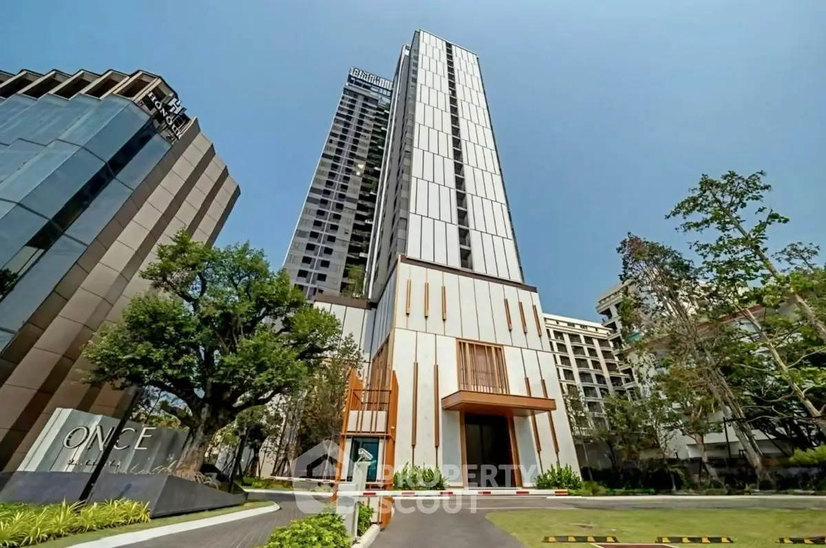 Stunning modern high-rise building with sleek architecture and lush landscaping in prime urban location.
