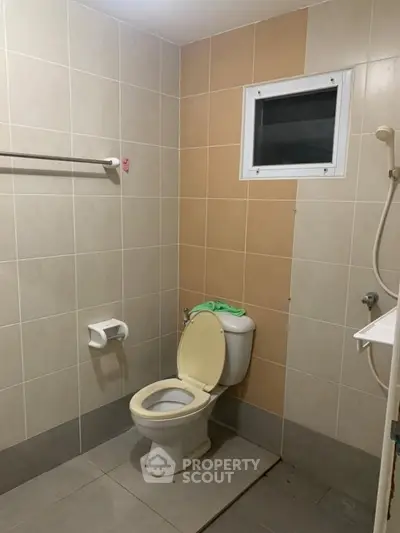 Simple bathroom with tiled walls and basic fixtures