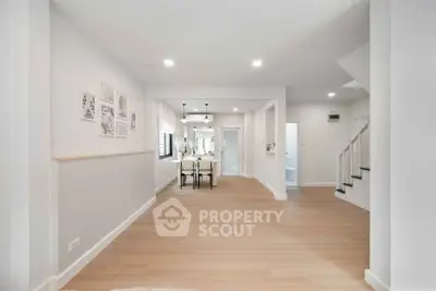 Spacious modern living area with wooden flooring and elegant dining setup.