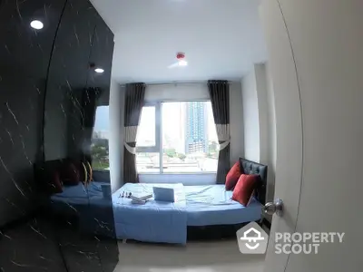 Modern bedroom with city view, featuring stylish decor and ample natural light.