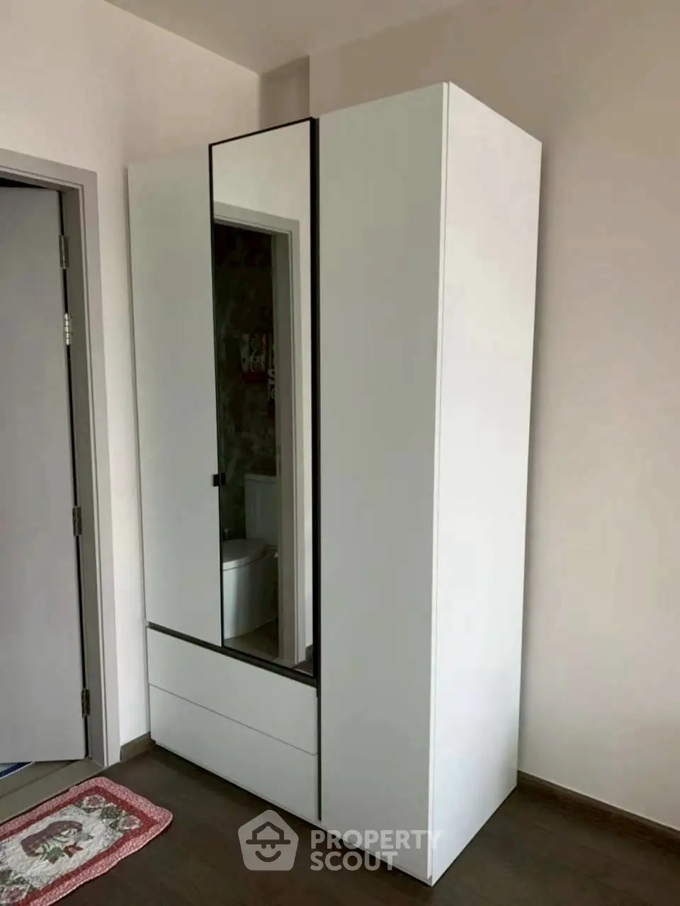 Modern bedroom with sleek white wardrobe and mirrored door