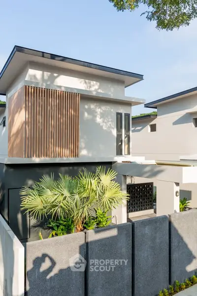 Modern two-story house with sleek design and lush greenery, perfect for contemporary living.