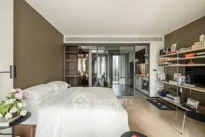 Modern bedroom with open layout and stylish decor, featuring a cozy bed and sleek shelving.