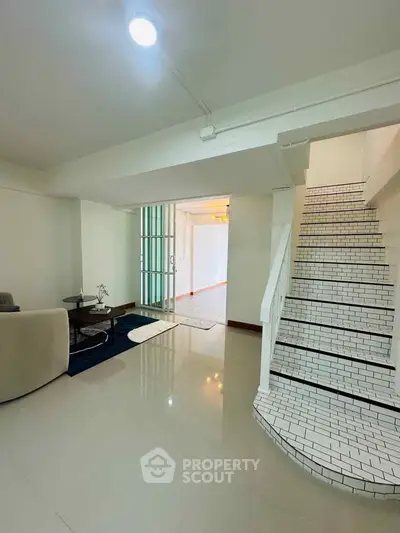 Spacious interior with modern staircase and cozy seating area, perfect for stylish living.