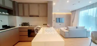 Modern open-layout kitchen and living room with sleek design and natural light.