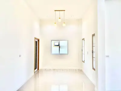Bright and spacious empty room with modern lighting and large windows.