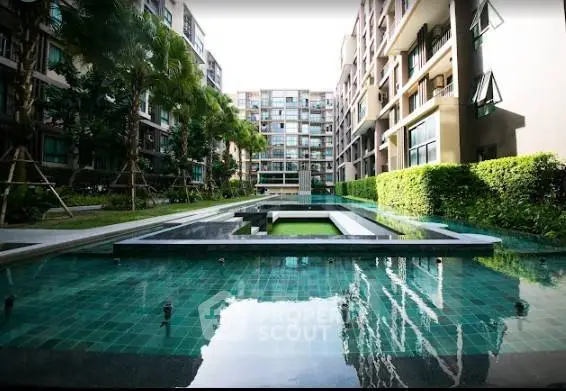 Luxurious modern apartment complex with serene pool and lush greenery