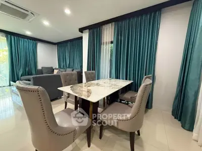 Elegant dining area with marble table and plush chairs in a modern living room setting.