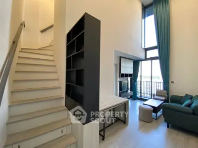 Modern duplex living room with high ceilings and stylish staircase