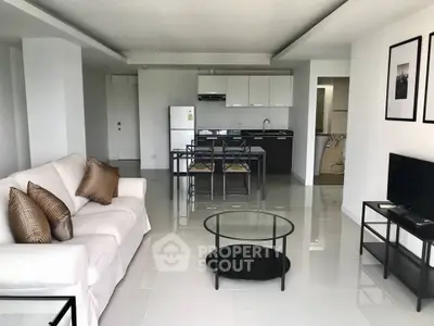 Spacious modern living room with open kitchen and sleek furnishings.