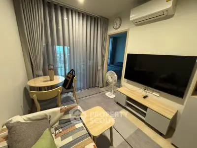 Modern living room with stylish furniture and large TV, featuring a cozy ambiance and natural light.