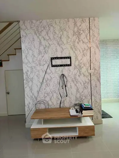 Modern interior with marble accent wall and wooden TV stand