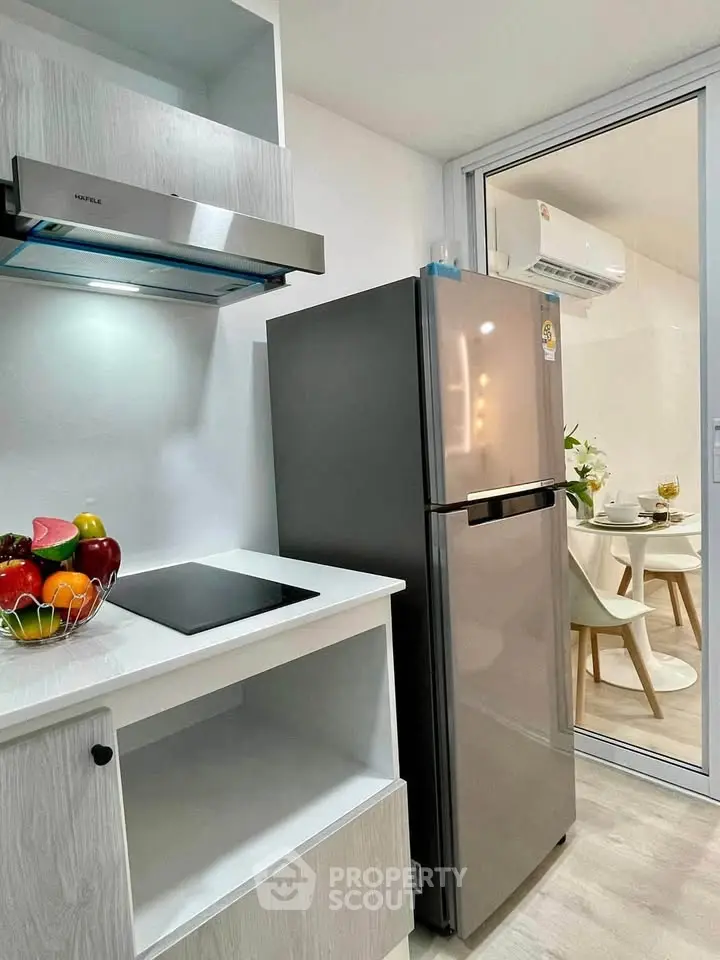 Modern kitchen with sleek appliances and dining area view, perfect for contemporary living.
