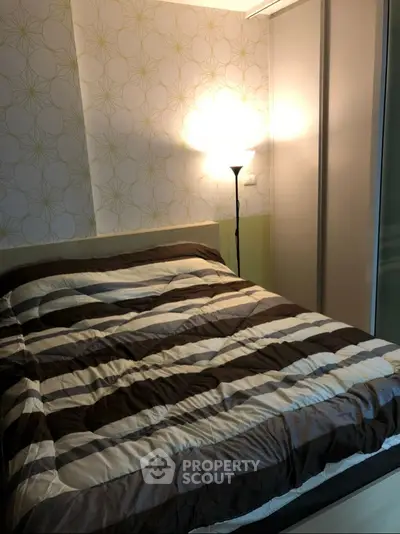 Cozy bedroom with modern decor and ambient lighting, featuring a stylish bed and elegant wallpaper.