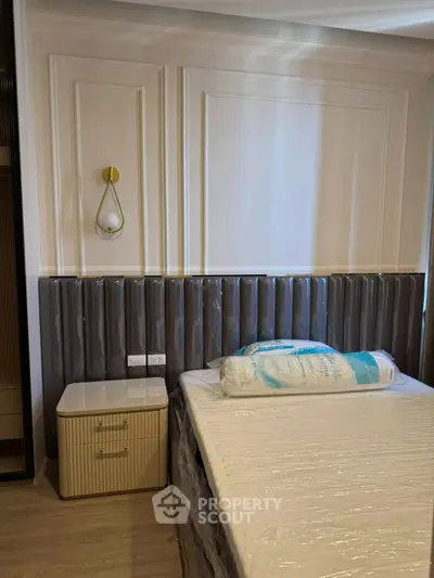 Modern bedroom with stylish paneling and elegant lighting, featuring a cozy bed and chic nightstand.
