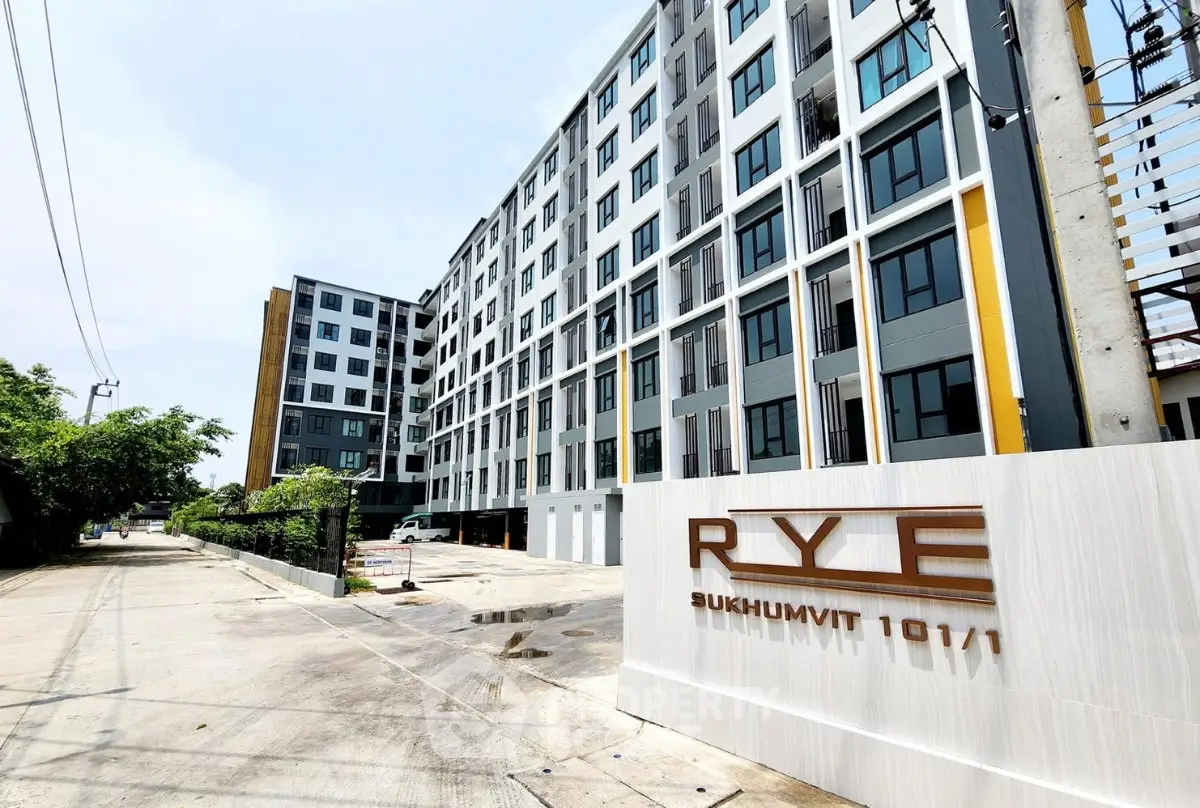 Modern apartment building exterior with sleek design at Rye Sukhumvit 101/1, showcasing urban living.