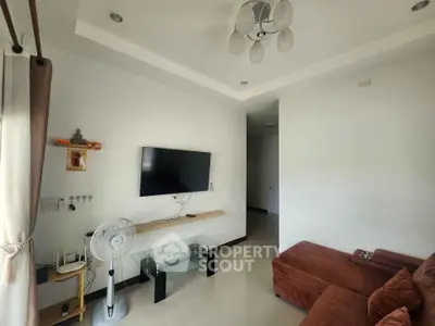 Modern living room with wall-mounted TV and cozy sofa, perfect for relaxation.