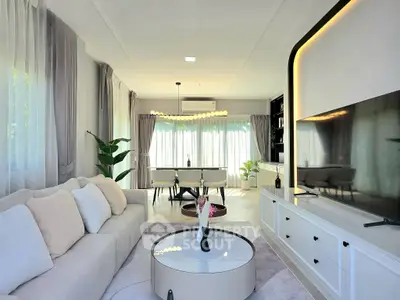 Elegant living room with modern decor and large windows, perfect for relaxation and entertainment.