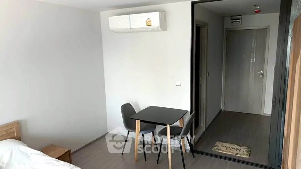 Modern apartment interior with minimalist dining area and air conditioning.