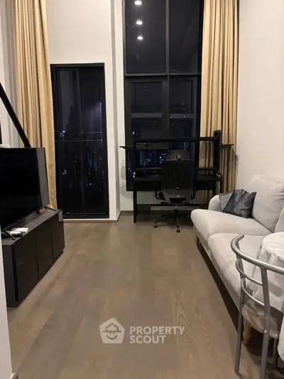 Modern living room with high ceilings and city view, featuring stylish furniture and large windows.