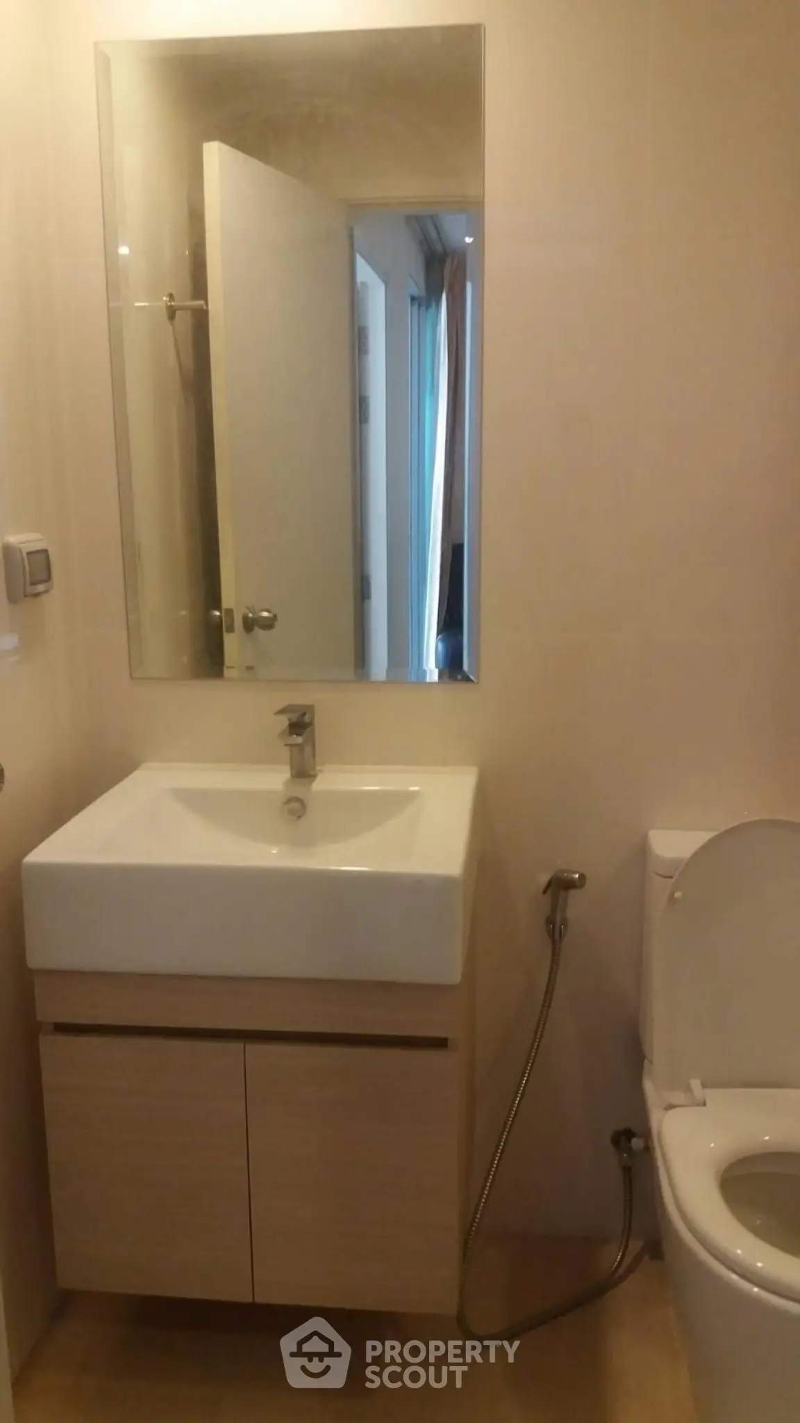 Modern bathroom with sleek sink and toilet in a compact space.