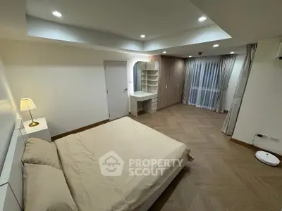 Spacious modern bedroom with elegant lighting and wooden flooring