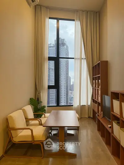 Modern living room with tall windows and city view, featuring cozy seating and wooden furniture.
