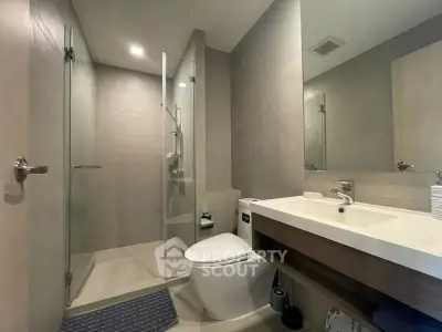 Modern bathroom with glass shower, sleek fixtures, and contemporary design.