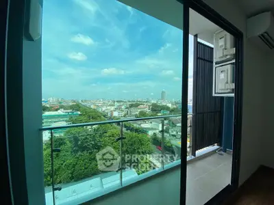 Stunning city view from modern apartment balcony with glass railing.
