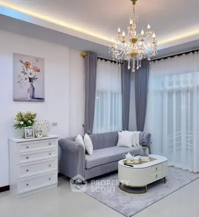 Elegant living room with chandelier, plush sofa, and stylish decor