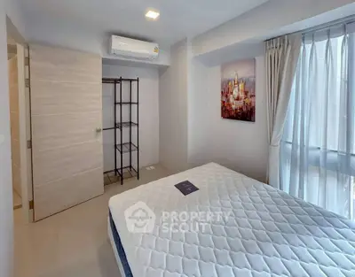 Modern bedroom with large window and air conditioning unit, featuring minimalist decor.