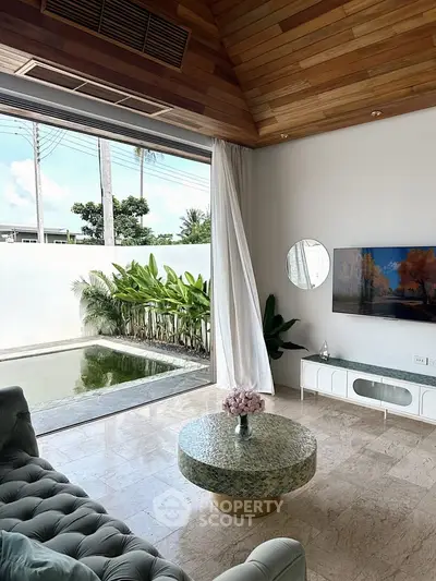 Luxurious living room with pool view, elegant decor, and natural light.