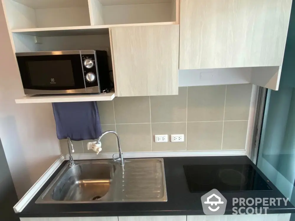 Modern kitchen with sleek black countertop and built-in microwave