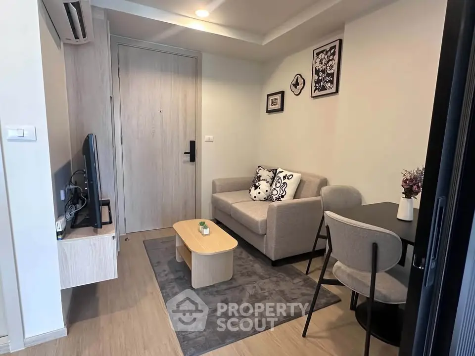 Cozy living room with modern decor and compact furniture in a stylish apartment.