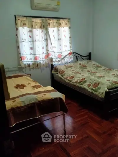Cozy bedroom with wooden flooring and charming decor